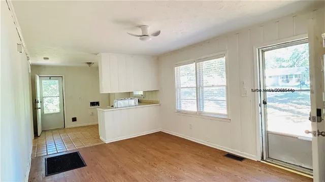 a view of a kitchen with wooden floor and a window