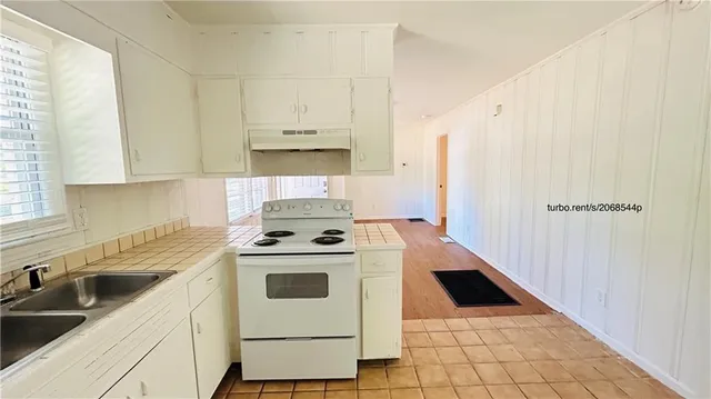 a kitchen with a stove a sink and a refrigerator