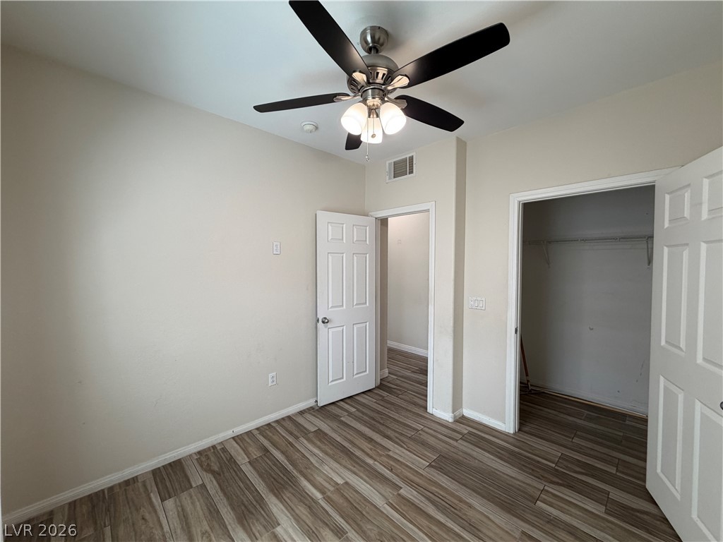 7701 West Robindale Road, Unit 236 Las Vegas, NV 89113 - Photo 14 of 15 A quiet bedroom featuring elegant wood-look flooring and a modern ceiling fan for comfort.