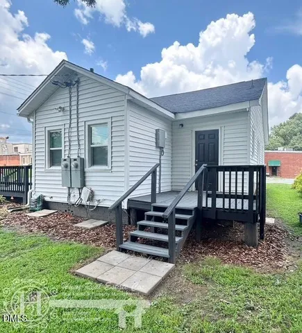a view of a house with backyard and sitting area