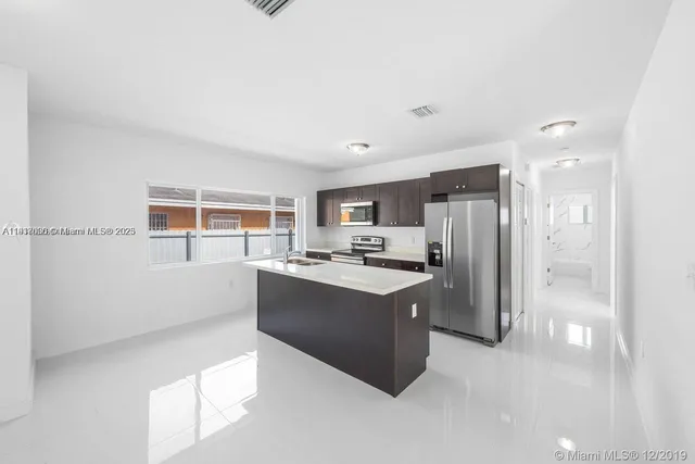 a kitchen with stainless steel appliances a refrigerator and a stove top oven