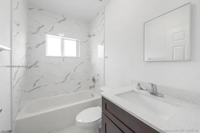 a bathroom with a sink toilet vanity and shower