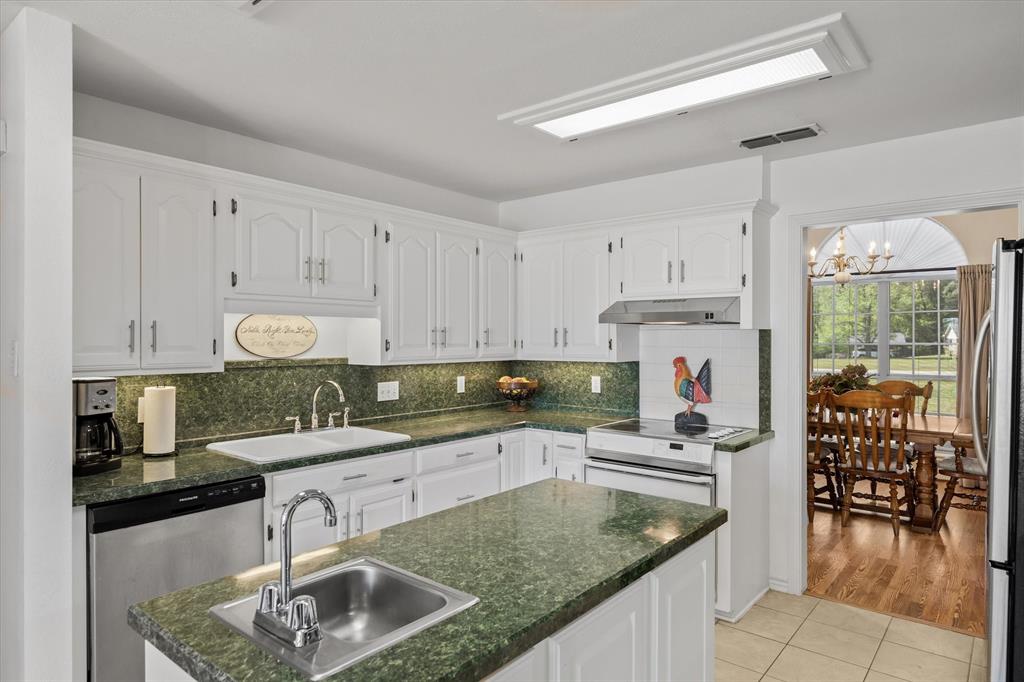 271 VZ County Road Canton, TX 75103 - Photo 16 of 40 a kitchen with granite countertop a sink a stove and cabinets
