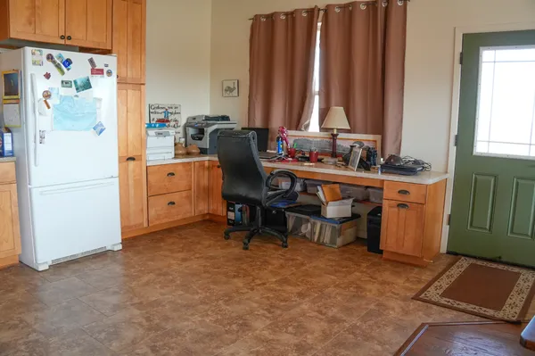 a view of a workspace with furniture and a window