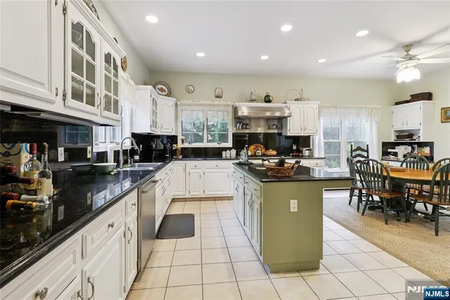 a kitchen with stainless steel appliances kitchen island granite countertop a stove and cabinets