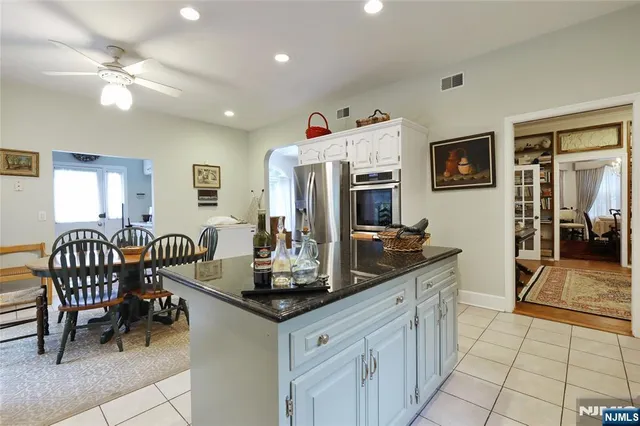 a kitchen with stainless steel appliances granite countertop a stove a sink a dining table and chairs