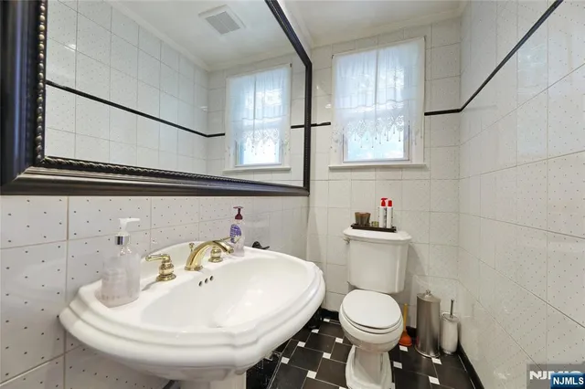 a bathroom with a sink a toilet and mirror