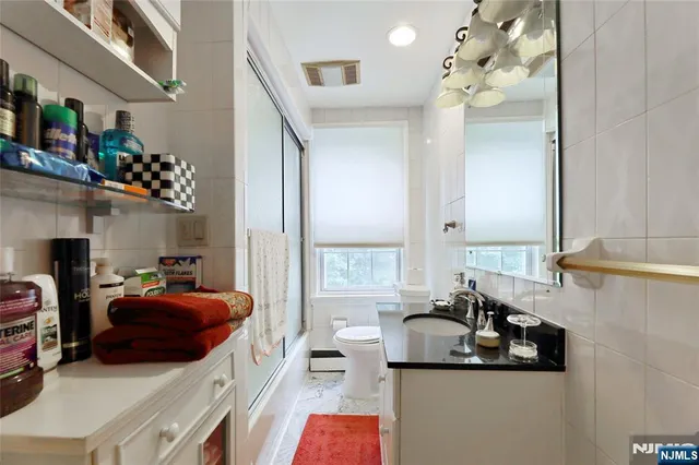 a bathroom with a sink vanity mirror and toilet