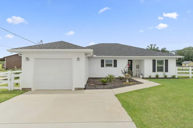 a front view of a house with a garden and patio