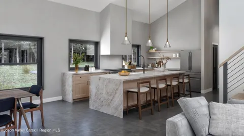 a kitchen with kitchen island granite countertop a sink a stove a dining table and chairs