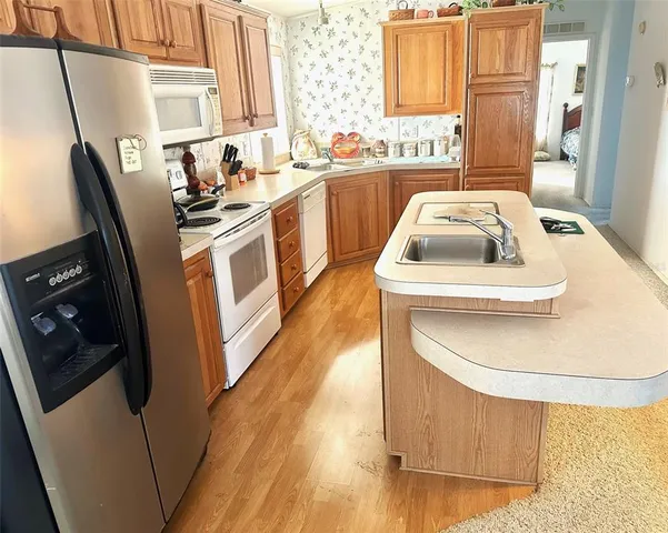 a kitchen with stainless steel appliances granite countertop a sink a stove a washer and dryer