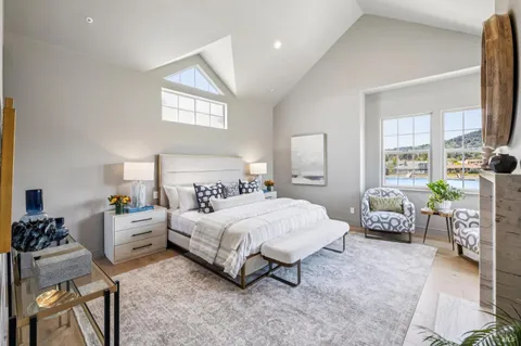 a bedroom with a bed potted plant on dresser and a window