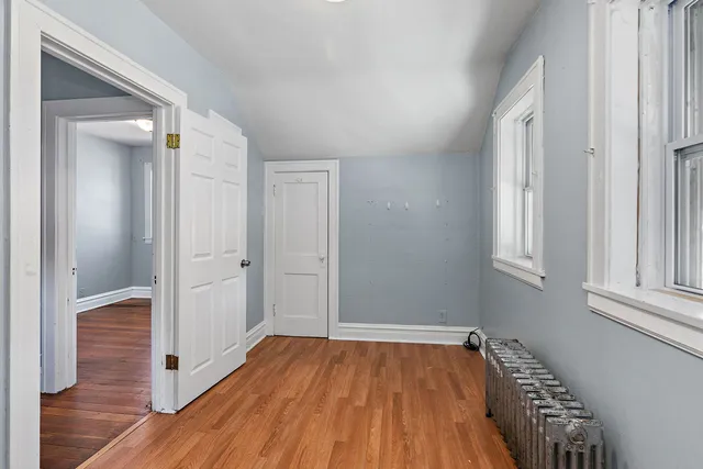 a view of a hallway with wooden floor and staircase