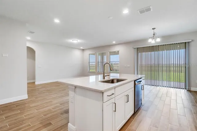 a kitchen with a sink window and wooden floor