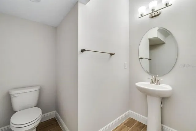 a bathroom with a sink toilet and a mirror