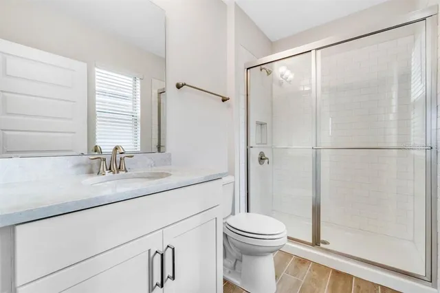 a bathroom with a granite countertop sink mirror vanity and toilet