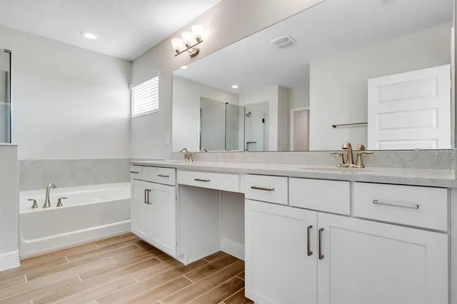a bathroom with a tub sink and mirror