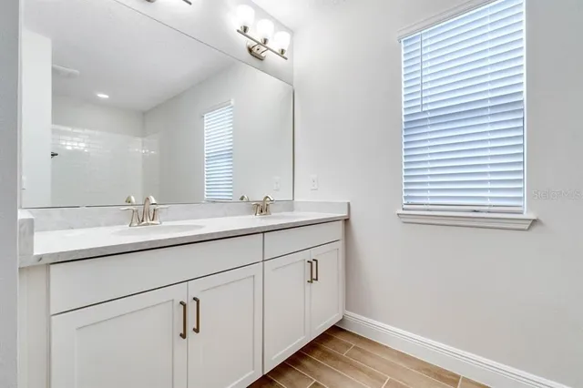 a bathroom with a double vanity sink and a mirror