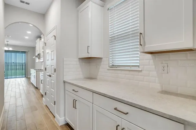 a kitchen with white cabinets and sink