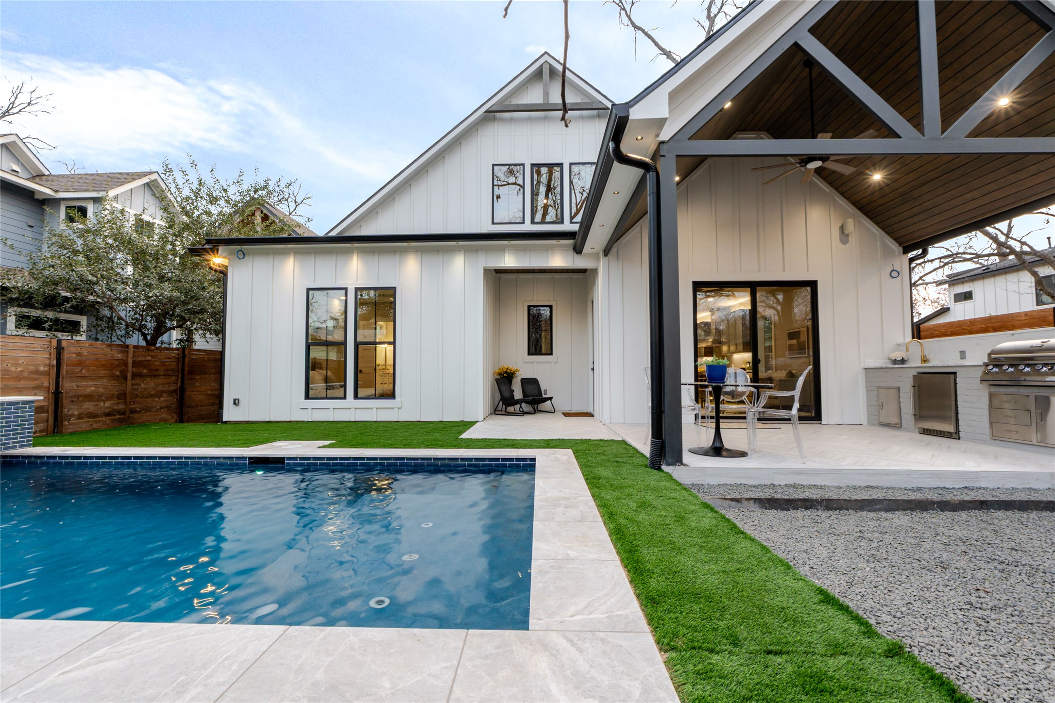Back of house featuring an outdoor kitchen, ceiling fan, a patio area, and board and batten siding