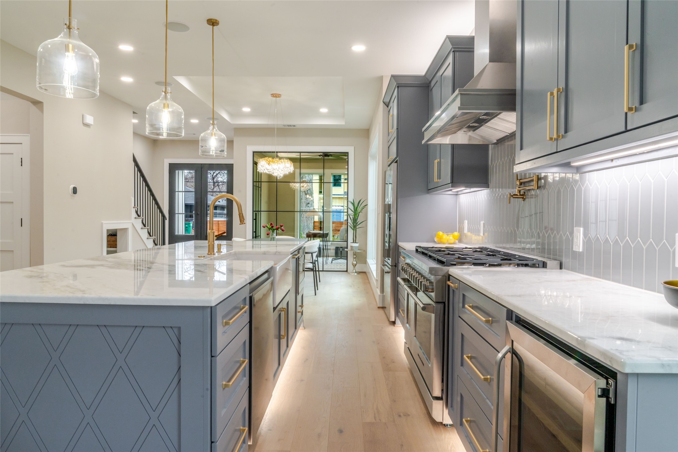 3100 Garwood Street Austin, TX 78702 - Photo 9 of 35 Kitchen with light stone counters, stainless steel appliances, light wood-style flooring, pendant lighting, and a raised ceiling