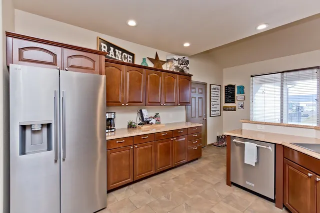 a kitchen with stainless steel appliances granite countertop a refrigerator and a sink