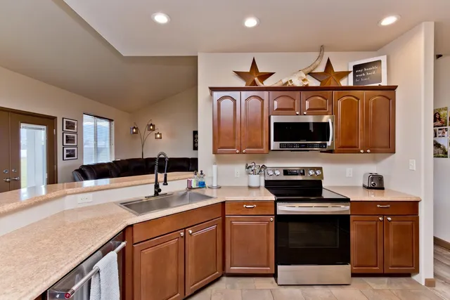 a kitchen with stainless steel appliances granite countertop a sink and a stove