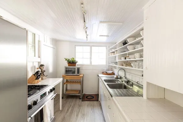 a kitchen that has a sink and chairs