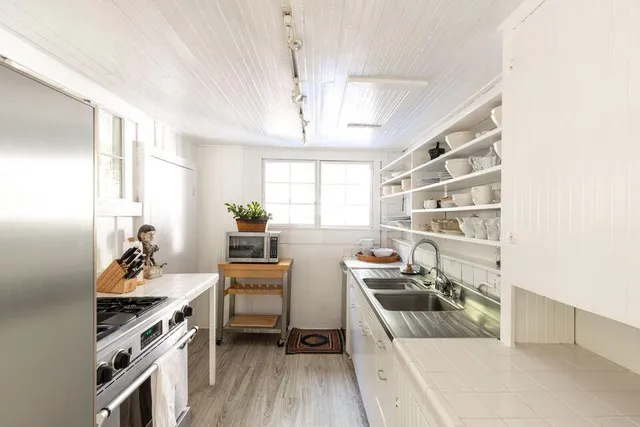 a kitchen that has a sink and chairs