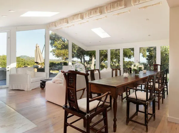 a view of a dining room with furniture large windows and wooden floor