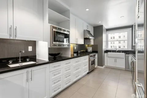 a kitchen with granite countertop white cabinets and white appliances