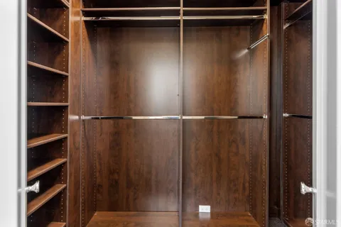 a view of walk in closet with empty racks