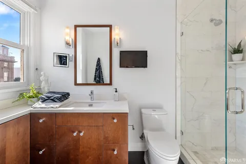a bathroom with a granite countertop sink toilet and shower