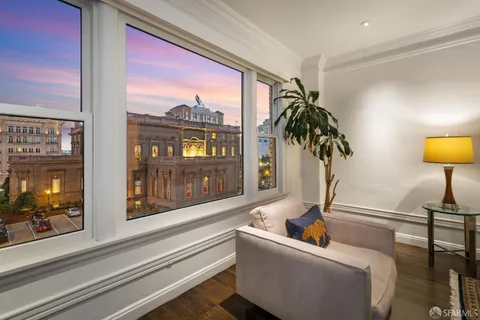 a living room with furniture and a large window with garden view