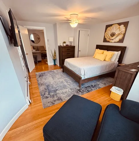 a kitchen with stainless steel appliances granite countertop a sink a stove a dining table and chairs with wooden floor