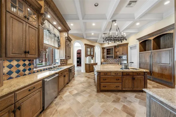 a large kitchen with stainless steel appliances double vanity and a counter top space
