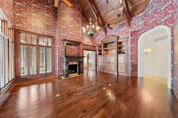a view of a livingroom with wooden floor and a fireplace
