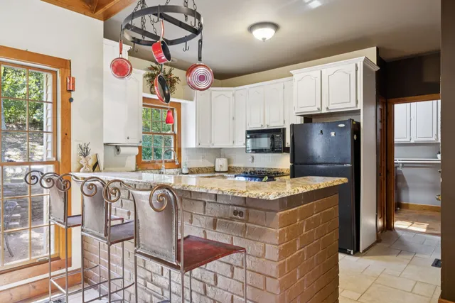 a kitchen with stainless steel appliances granite countertop a stove a sink and a refrigerator
