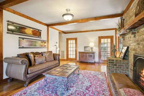 a living room with furniture hard wood floor and a rug