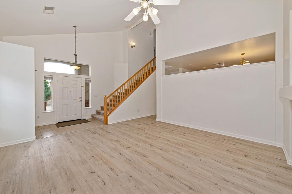 3524 Riojo Way Rancho Cordova, CA 95670 - Photo 7 of 47 a view of an empty room with wooden floor stairs and a chandelier