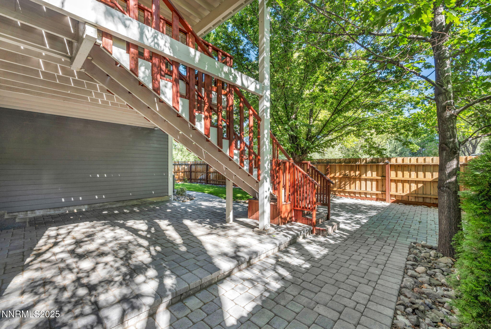1478 Clough Road Reno, NV 89509 - Photo 24 of 32 a backyard of a house with large trees and a wooden bench