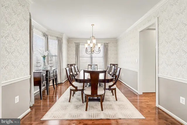 a kitchen with stainless steel appliances kitchen island granite countertop a dining table chairs and white cabinets