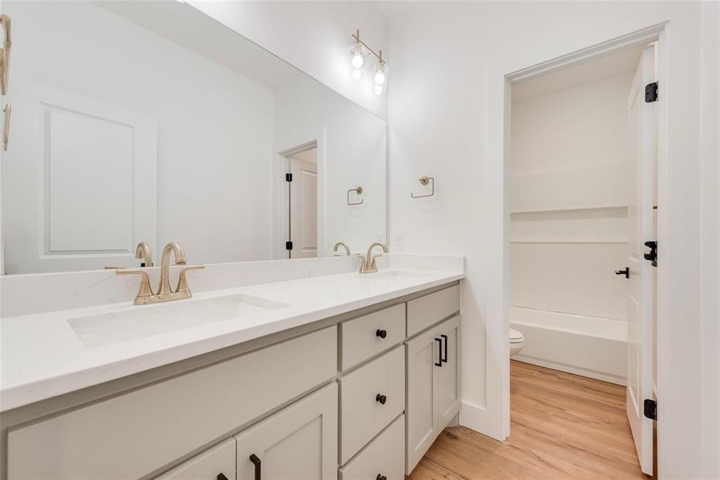 1807 Franklin Street Bonham, TX 75418 - Photo 8 of 13 a bathroom with a double vanity sink and a mirror