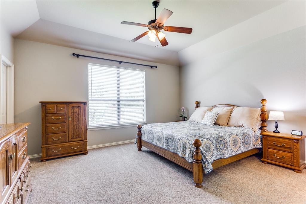 400 Commonwealth Drive Saginaw, TX 76179 - Photo 15 of 32 a spacious bedroom with a bed and a ceiling fan