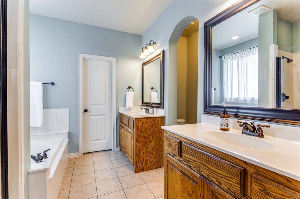 400 Commonwealth Drive Saginaw, TX 76179 - Photo 16 of 32 a spacious bathroom with a double vanity sink a mirror and a bathtub