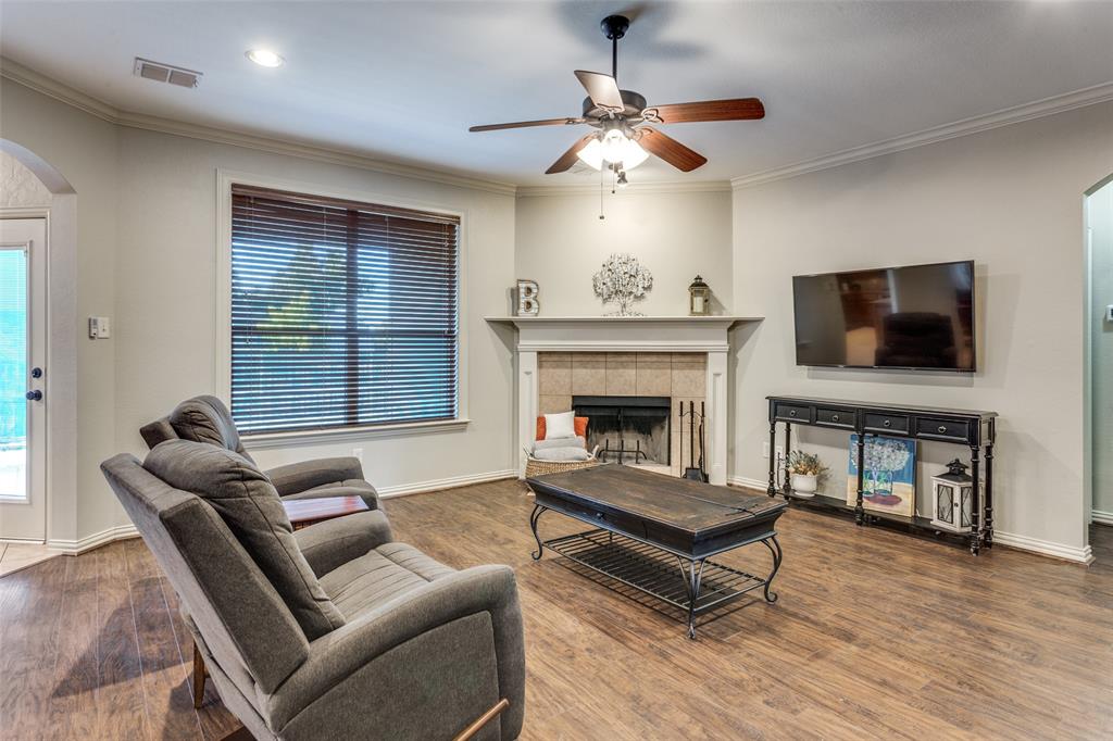 400 Commonwealth Drive Saginaw, TX 76179 - Photo 7 of 32 a living room with furniture a flat screen tv and a fireplace