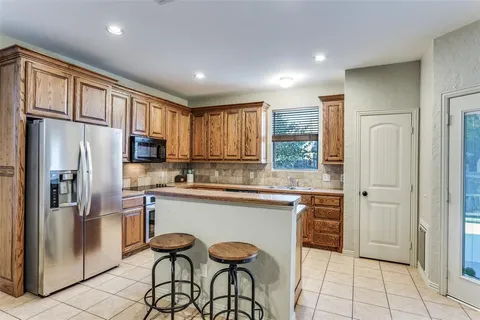 a kitchen with stainless steel appliances granite countertop a refrigerator and a stove top oven