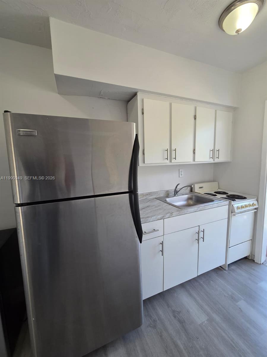 1628 Southwest 7th Street, Unit 8 Miami, FL 33135 - Photo 1 of 8 a kitchen with a refrigerator and cabinets