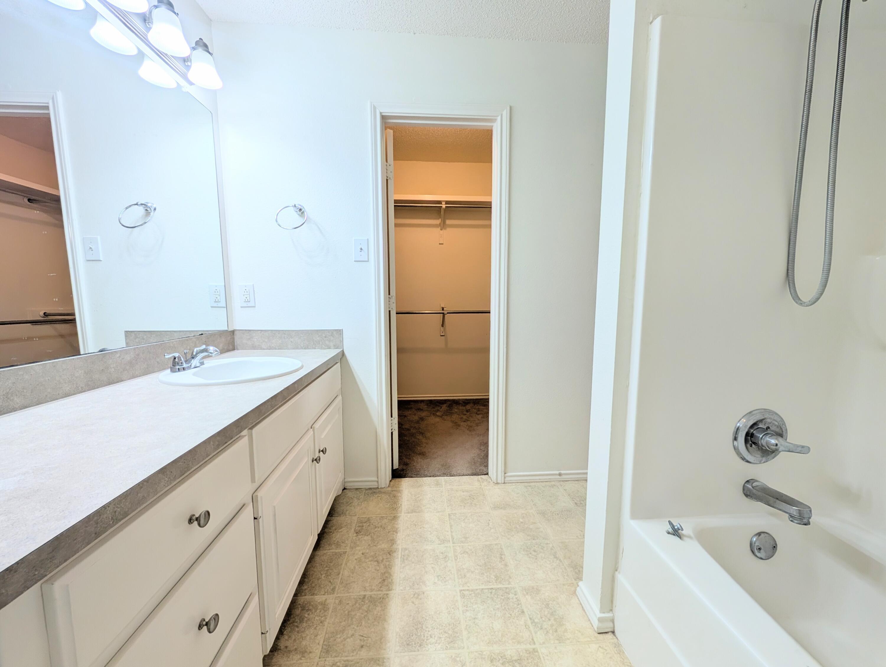 2417 87th Street, Unit B Lubbock, TX 79423 - Photo 7 of 11 a spacious bathroom with a tub sink and mirror