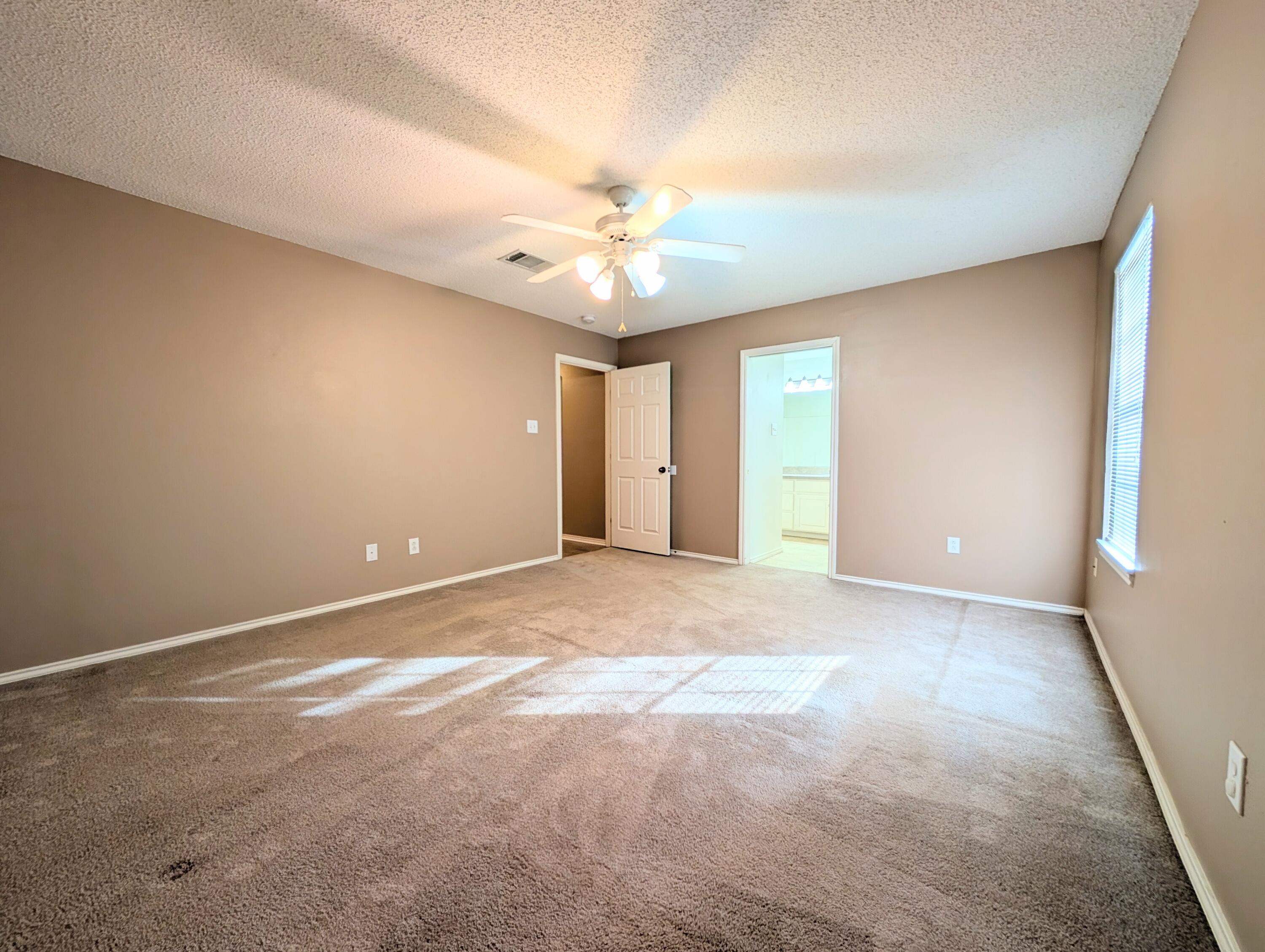 2417 87th Street, Unit B Lubbock, TX 79423 - Photo 9 of 11 a view of an empty room with a window